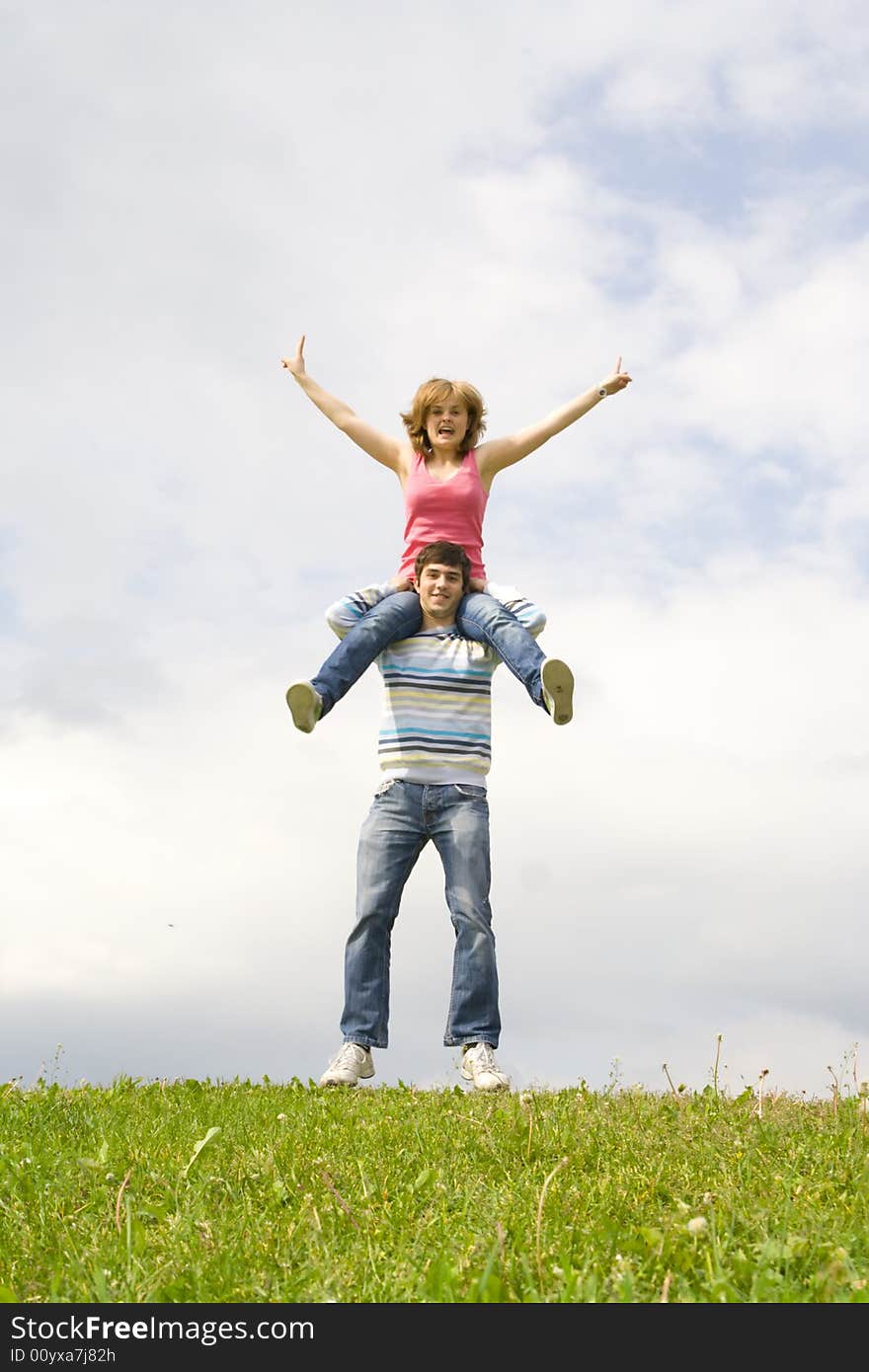 Young happy couple standing on a green grass