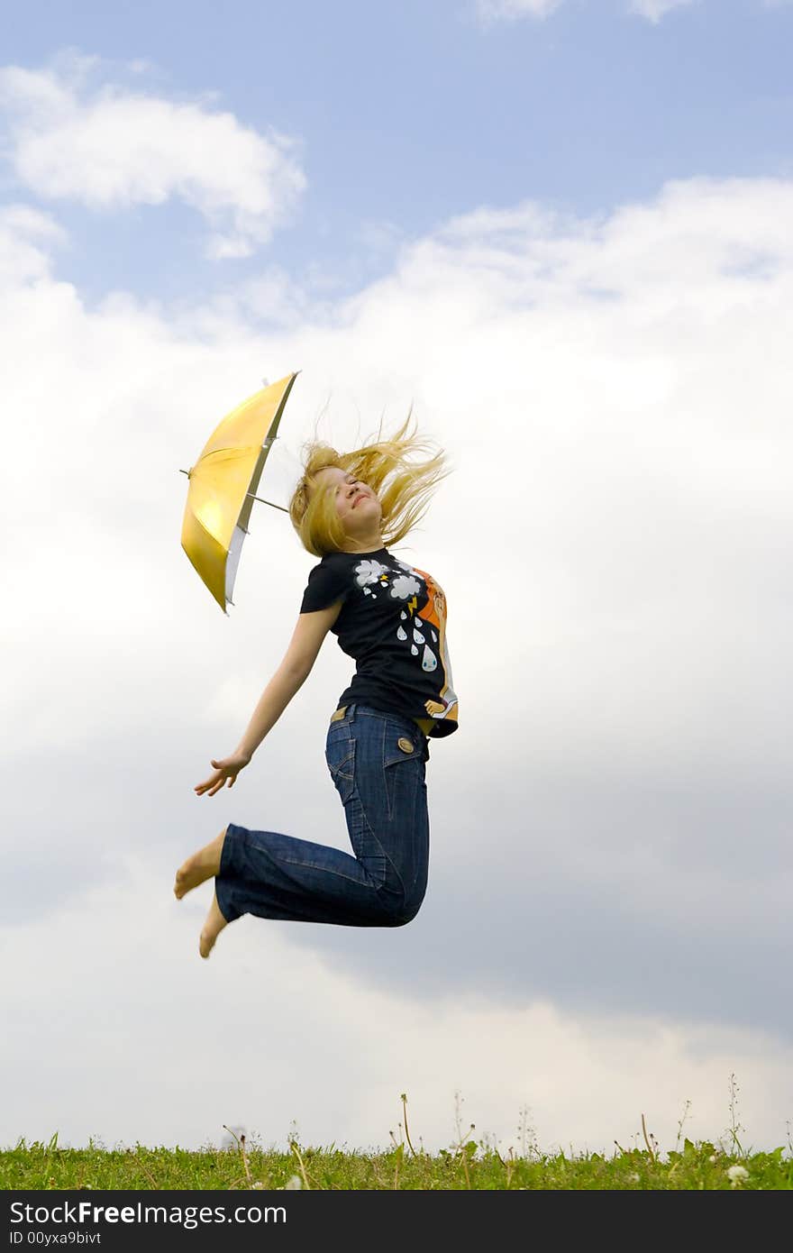 The young happy girl jumping with a umbrella