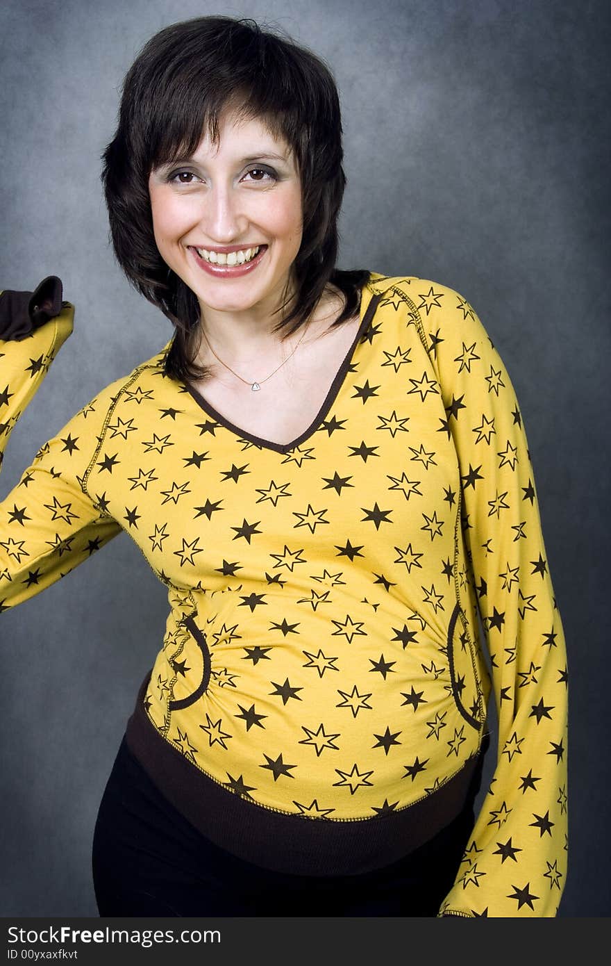 Energetic laughing expecting mother in a yellow pijamas with stars