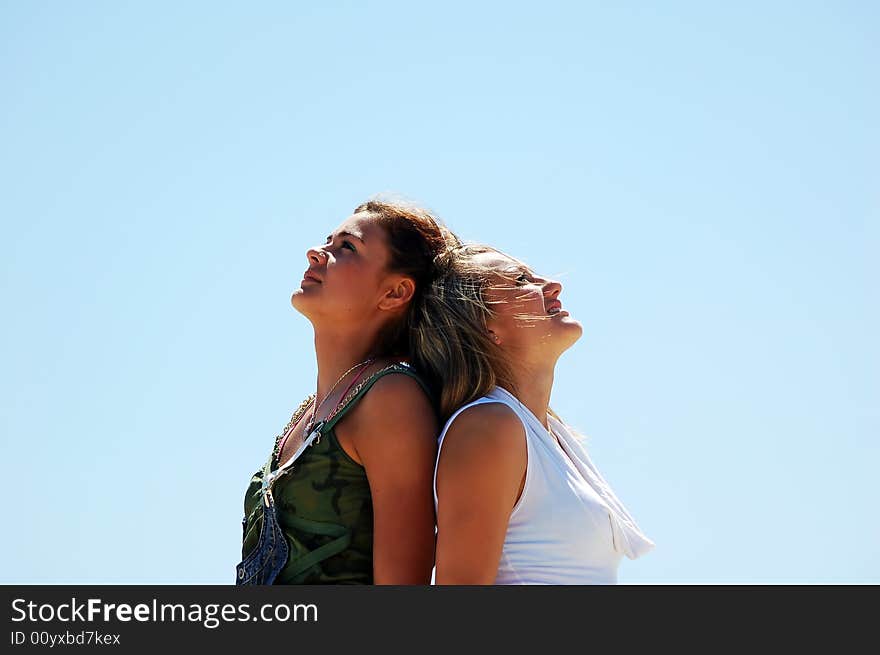 Young attractive girls looking up to the sky. Young attractive girls looking up to the sky