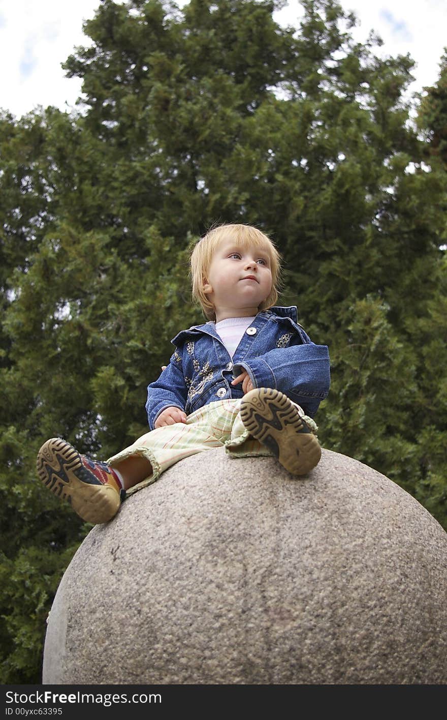 The beautiful little girl sits on a sphere. The beautiful little girl sits on a sphere