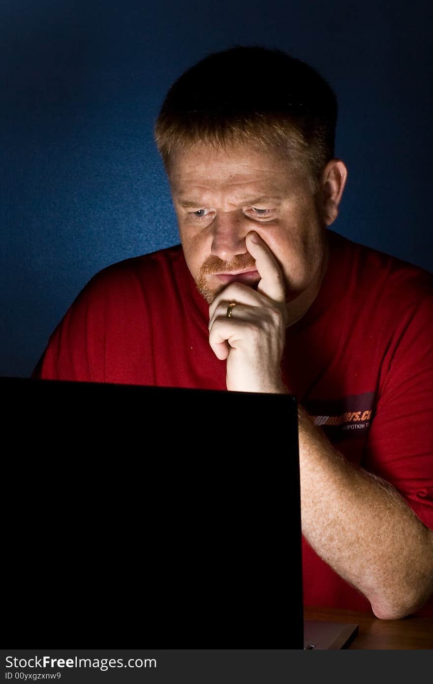 A man looking at a Notebook computer looking perplexed. A man looking at a Notebook computer looking perplexed