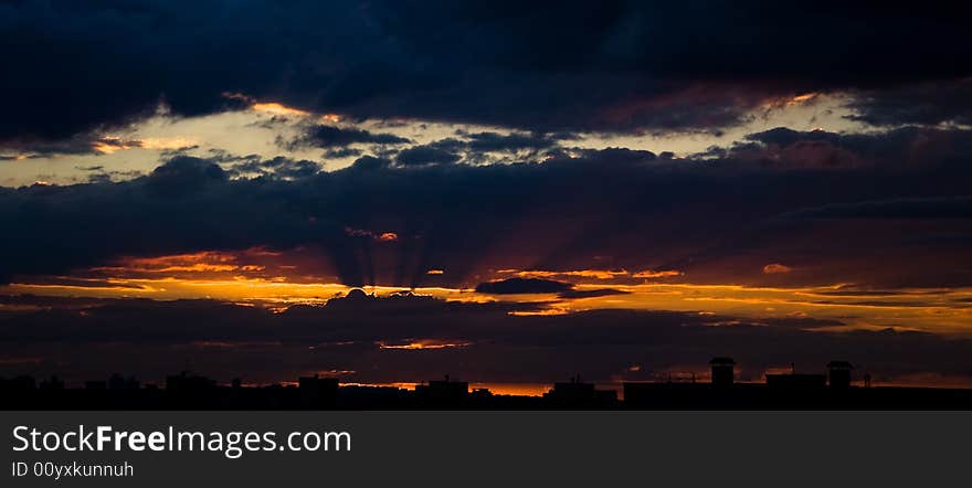 Silhouette of the roofs of houses at sunset.