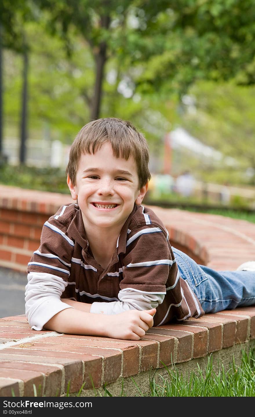 Little Boy Laying Down on Brick Wall. Little Boy Laying Down on Brick Wall