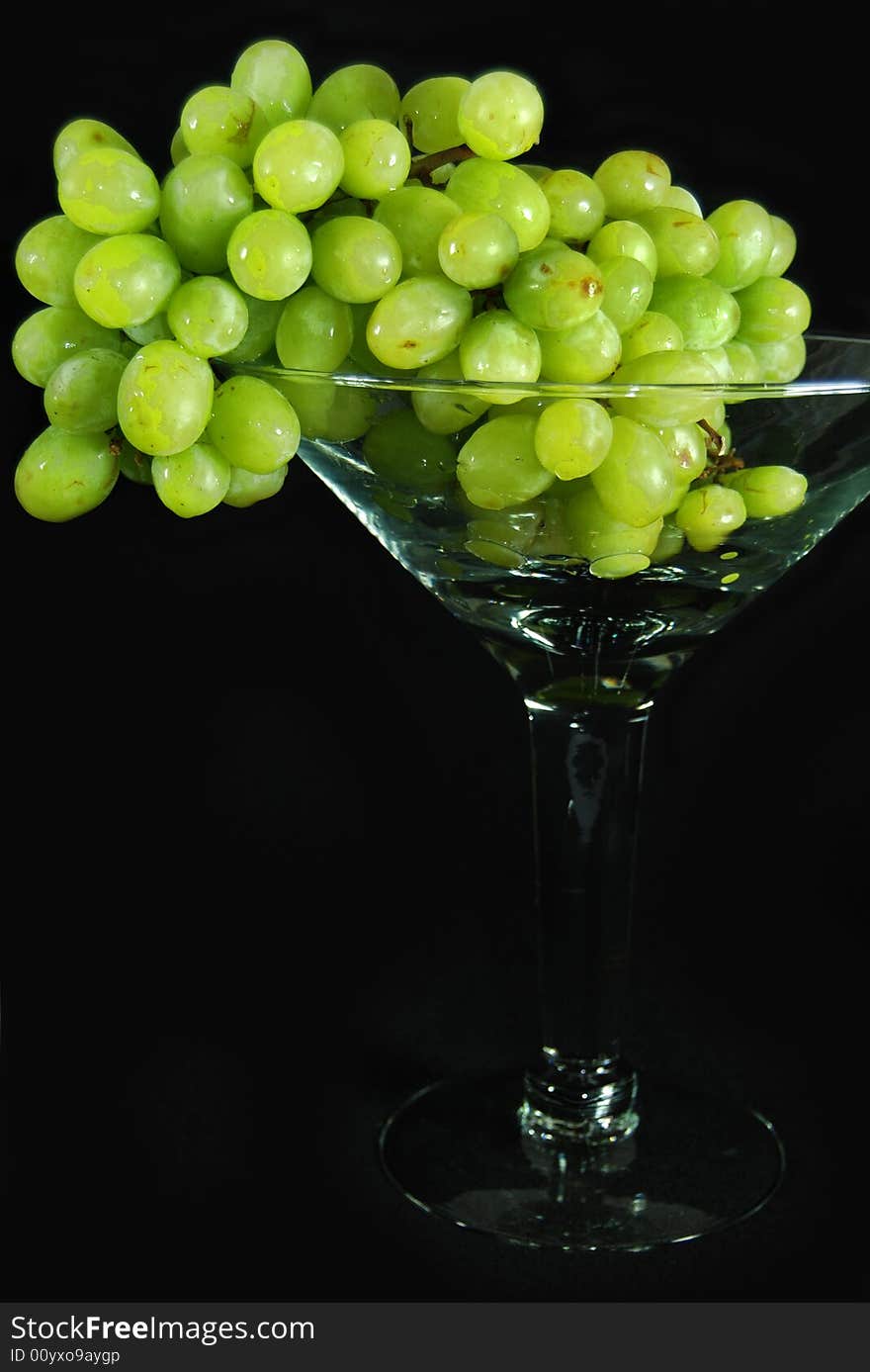 Ripe and juicy green grapes in a glass goblet. Ripe and juicy green grapes in a glass goblet.