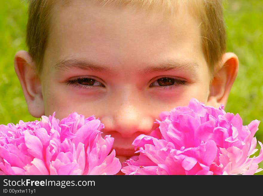 The boy of eight years it smiles smelling the flowers. The boy of eight years it smiles smelling the flowers