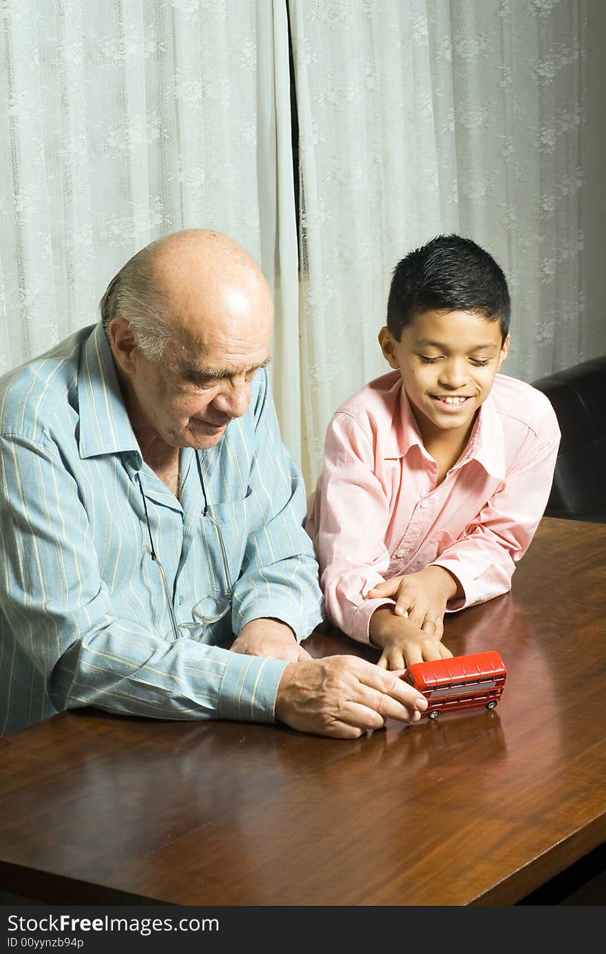 Grandfather And Grandson Sitting On Table - Vertic