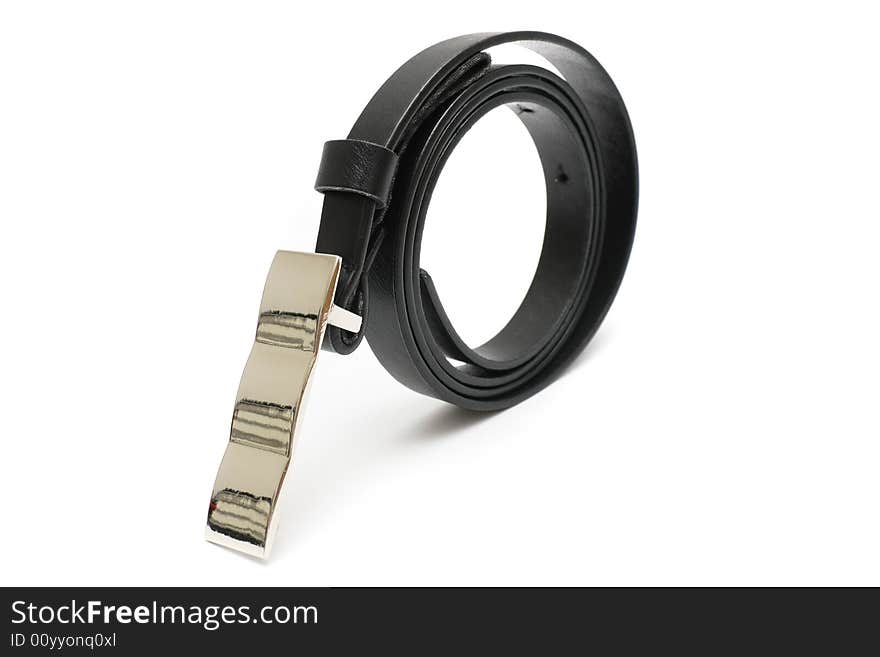 A rolled up black color trousers belt stand on white background. A rolled up black color trousers belt stand on white background.