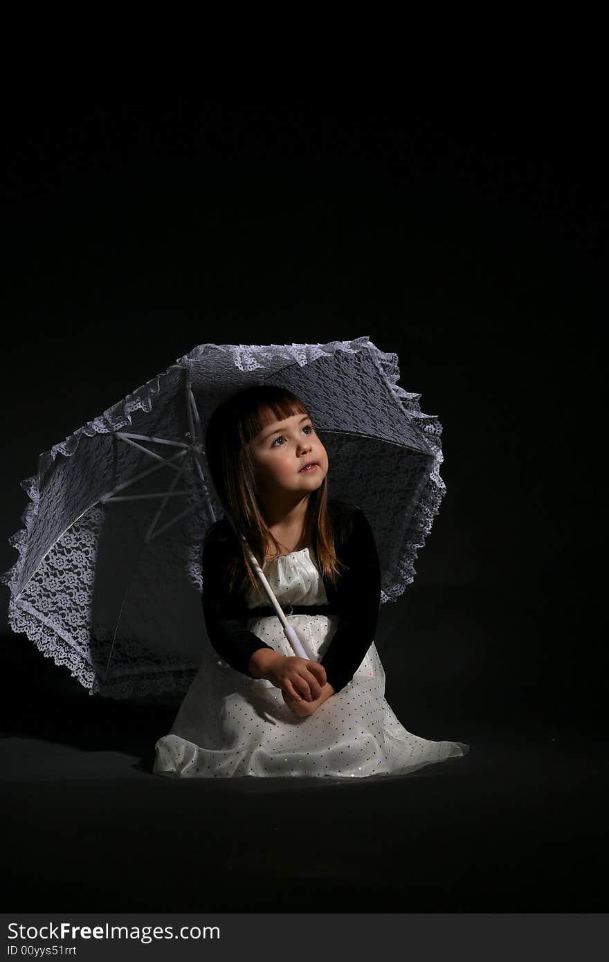 Little girl with chubby cheeks, holding a parasol and looking up. Little girl with chubby cheeks, holding a parasol and looking up