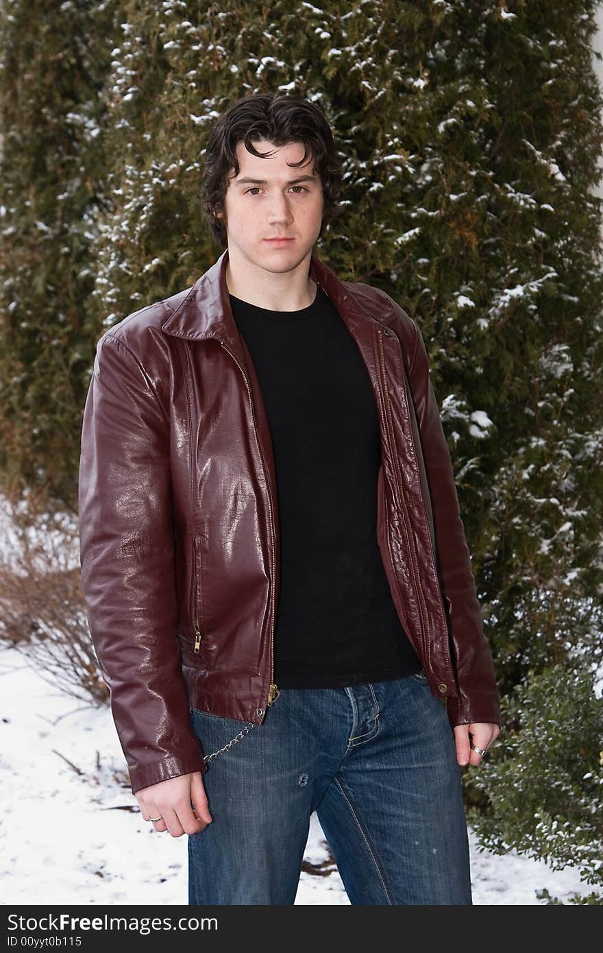 Man posing in front of snow covered trees.