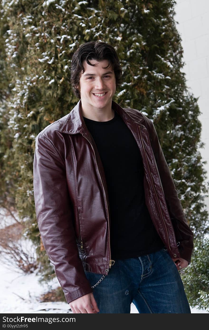 Man posing in front of snow covered trees.