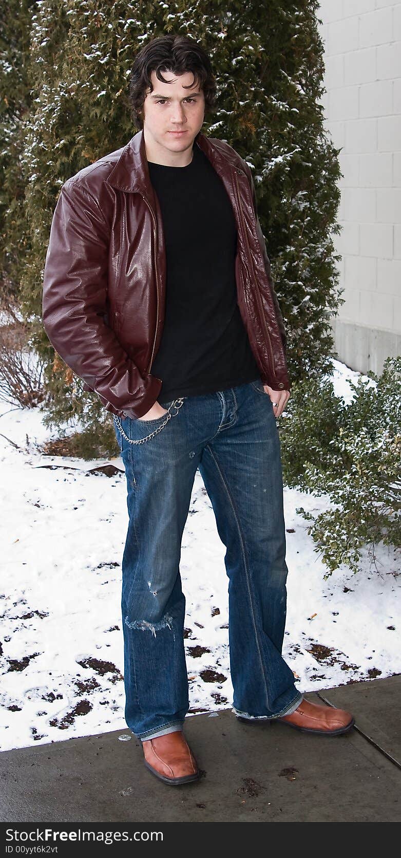 Man posing in front of snow covered trees.