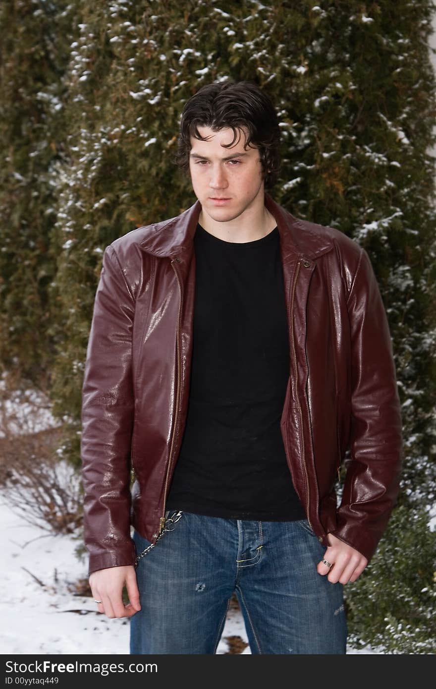 Man posing in front of snow covered trees.