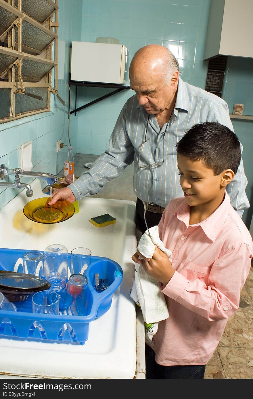 Grandfather And Grandson Washing Dishes - Vertical