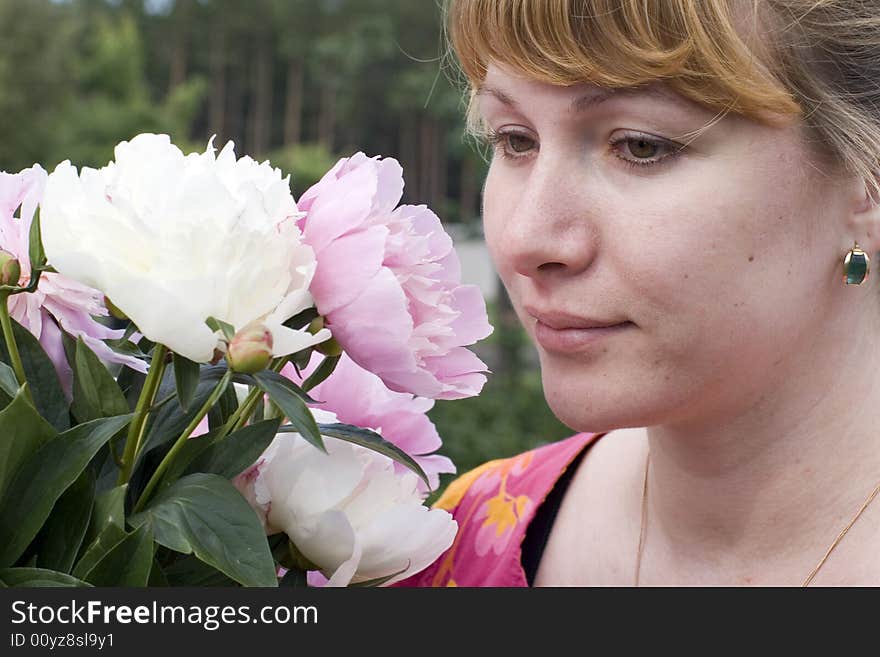 Beautiful young woman holding pink peony