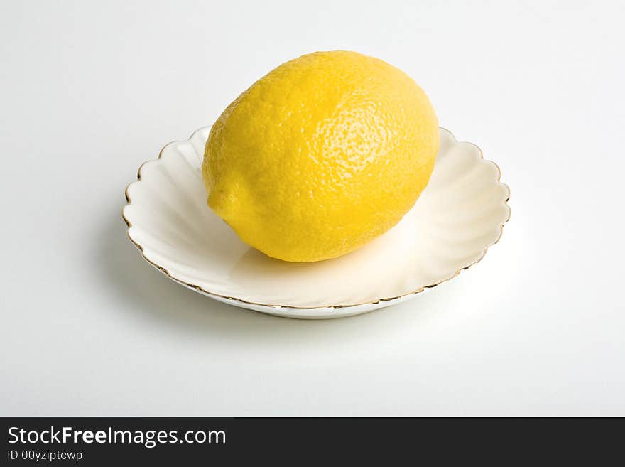 Lemon on a plate. Isolated on the white background.