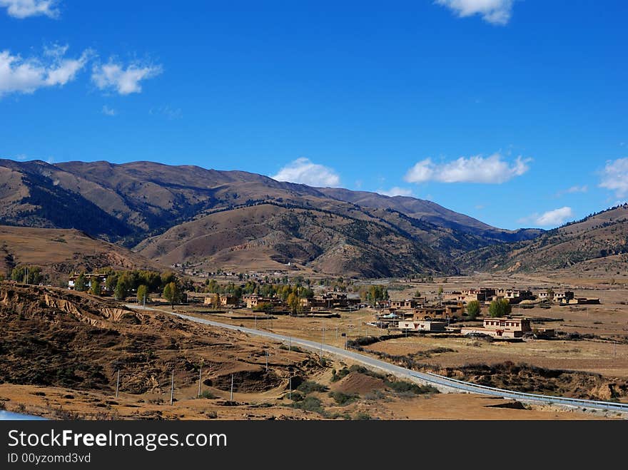 A small village on the way .A mountain landscape with blue sky. A small village on the way .A mountain landscape with blue sky