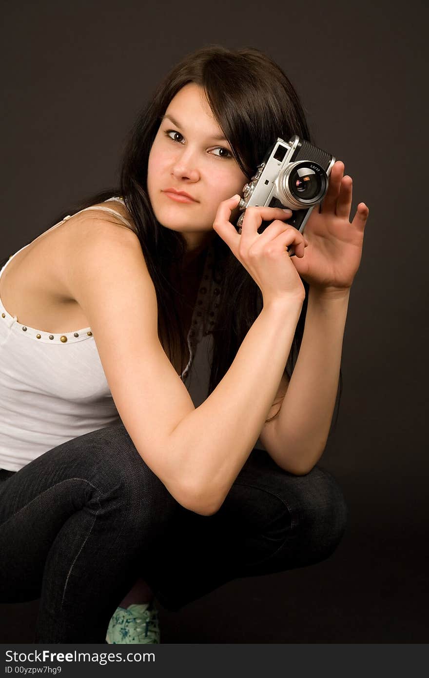 Fashion girl posing with camera isolated on black background. Fashion girl posing with camera isolated on black background