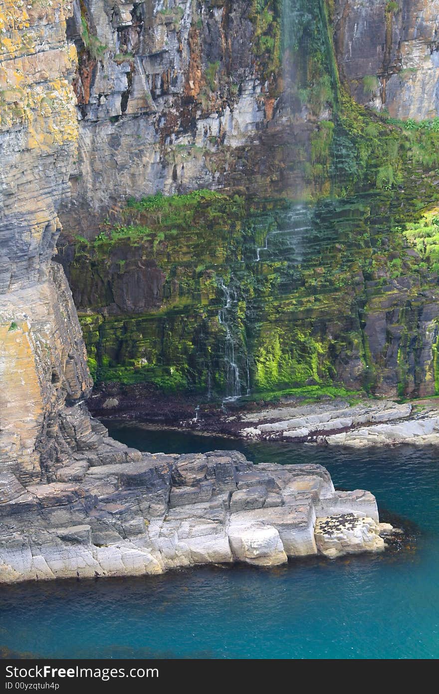 Lovely blue water, small waterfall, it could be paradise anywhere in the tropics, but it's the far north of Scotland at Whaligoe.