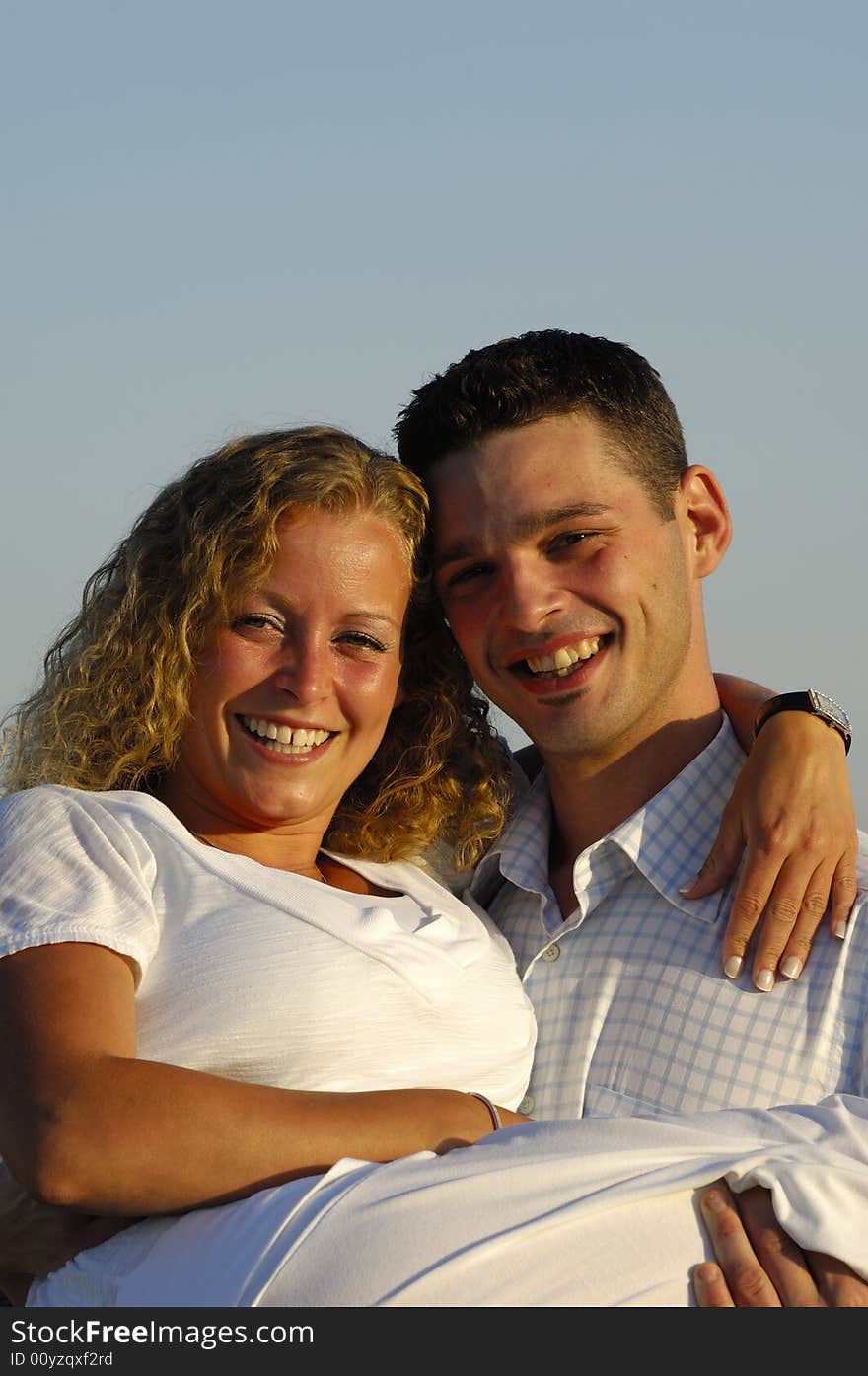 A sweet young couple is posing in the sun. A sweet young couple is posing in the sun.