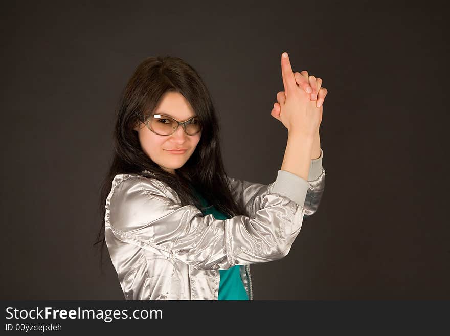 Smiling girl pointing her hands like a gun isolated on black background