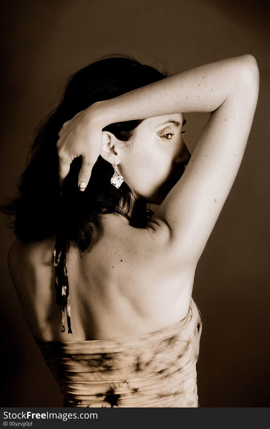 Portrait of seductive woman with raised arm - sepia tone. Portrait of seductive woman with raised arm - sepia tone