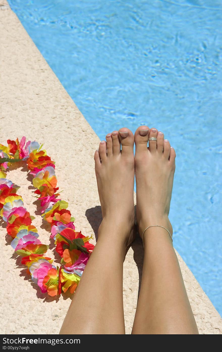 Legs and lei near a pool. Legs and lei near a pool