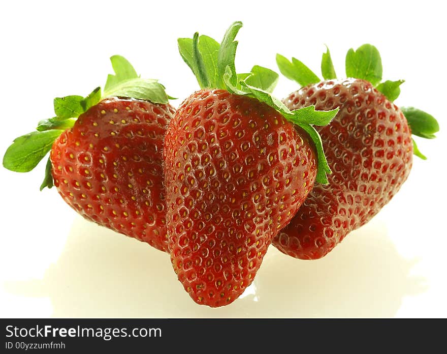 Close up shot of three ripe strawberry over white background