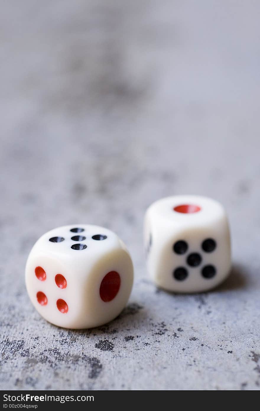 Photo of dice on a concrete floor.