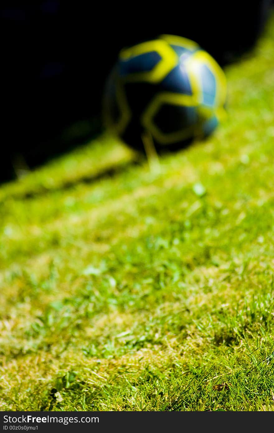 Yellow and black football on a field of grass