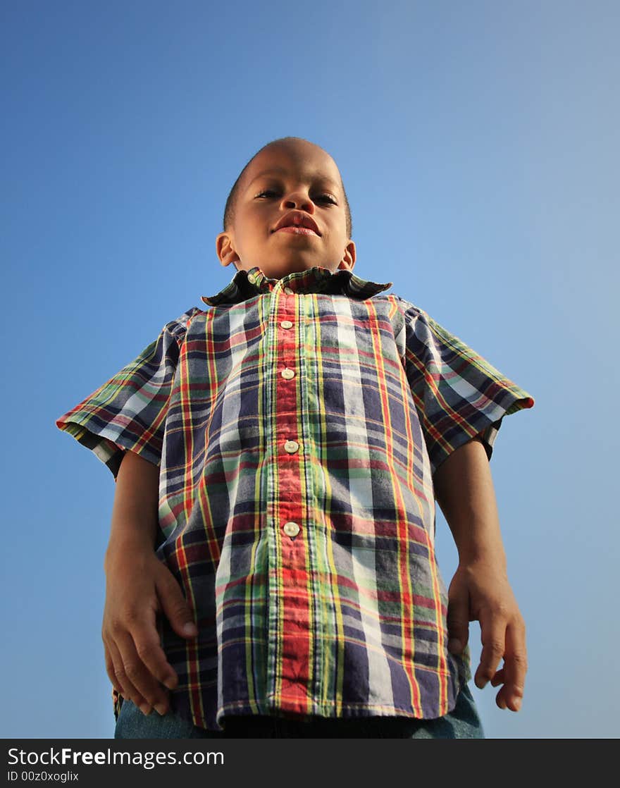 Low angle shot taken of a young boy looking down making him look like a giant. Low angle shot taken of a young boy looking down making him look like a giant.