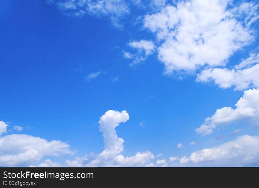 White cloud in the form of the head of dragon against the bright blue background of summer sky. White cloud in the form of the head of dragon against the bright blue background of summer sky.