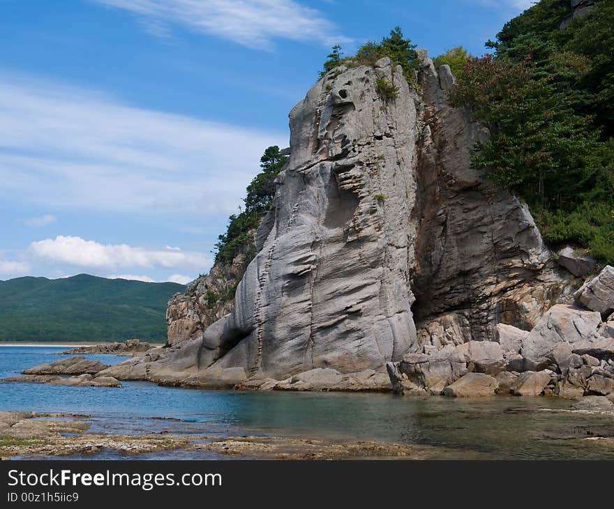 A very small bay among fancy rocks. Seacoast of Petrova island - pearl of nature state reserve Lazovsky. Russian Far East, Primorye. A very small bay among fancy rocks. Seacoast of Petrova island - pearl of nature state reserve Lazovsky. Russian Far East, Primorye.