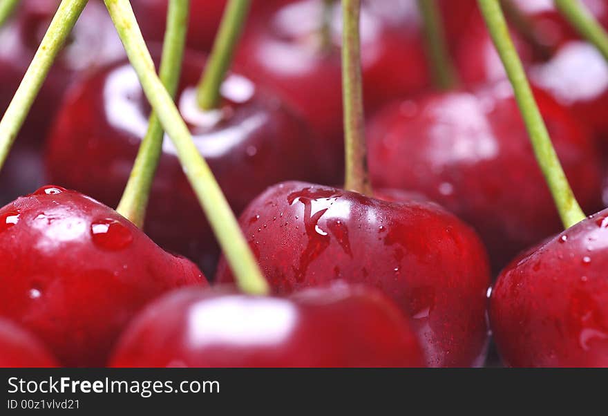 Fresh cherry with drops on background