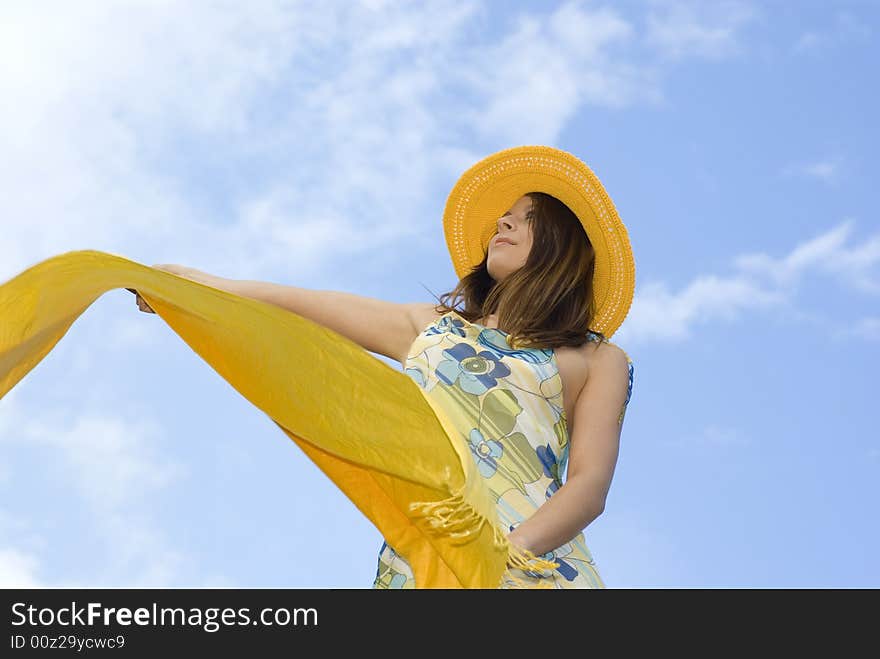 Young Woman Holding Orange Wrap Against Blue Sky