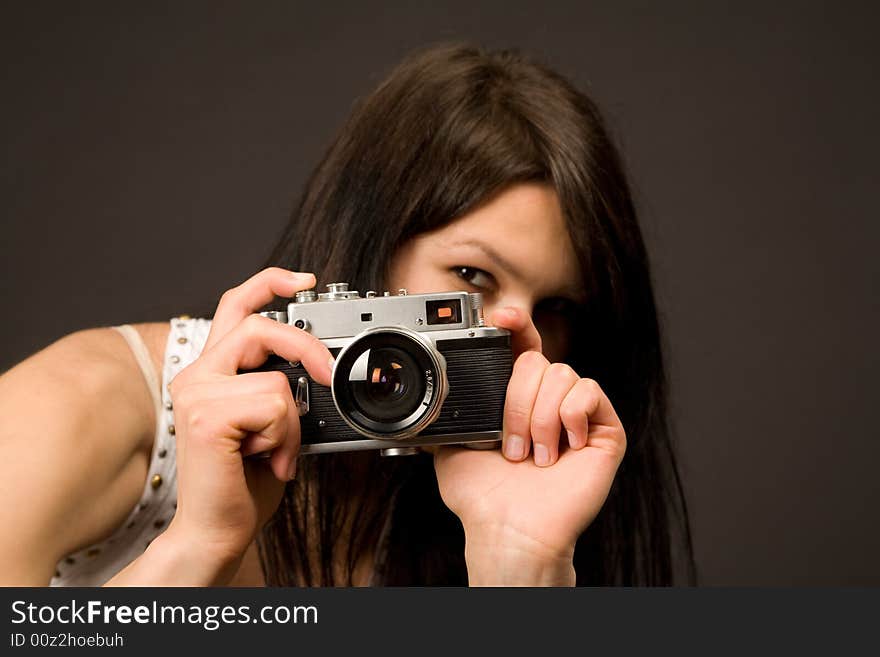 Playful girl with camera isolated on black background. Playful girl with camera isolated on black background