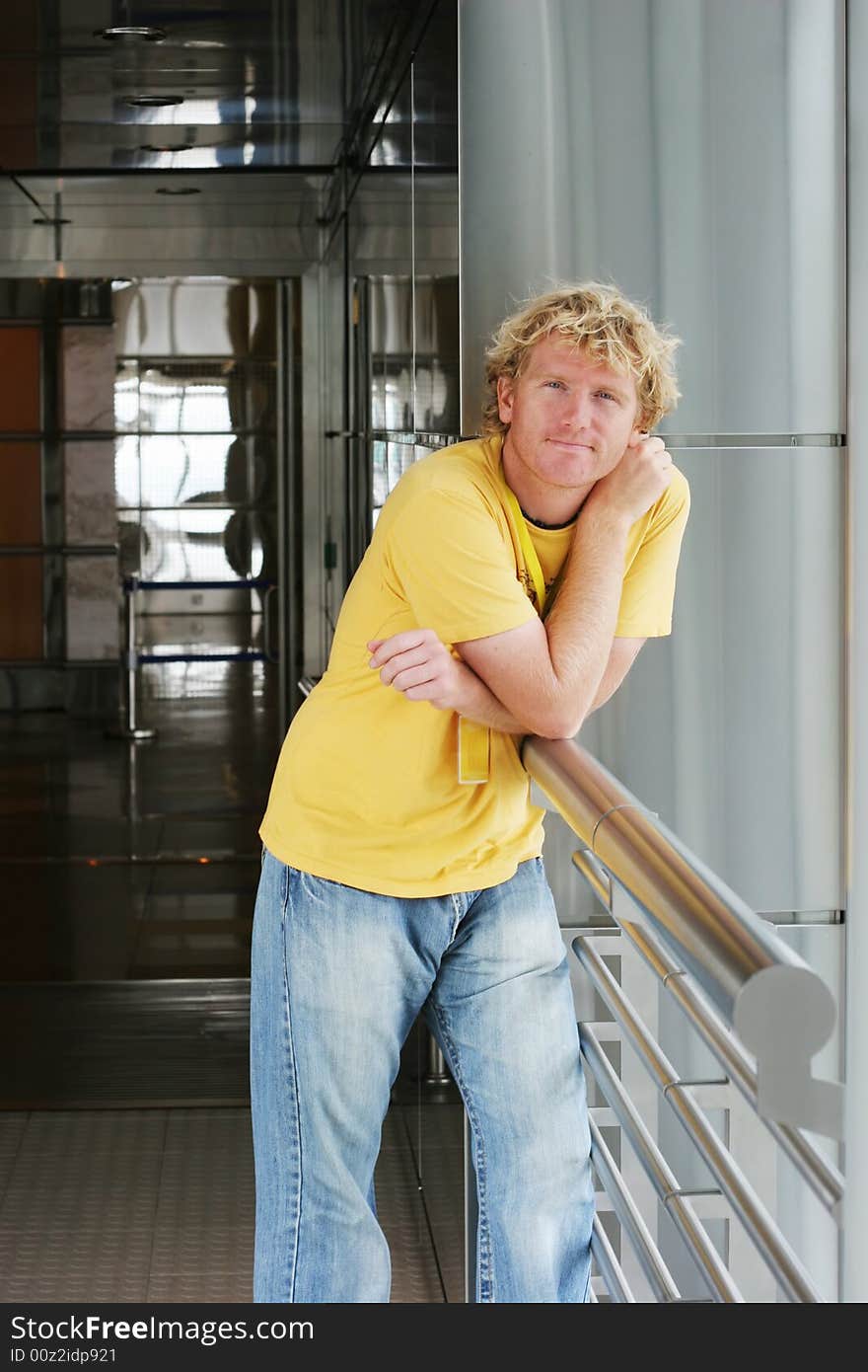 Portrait of a man leaning on the railing of an modern building.