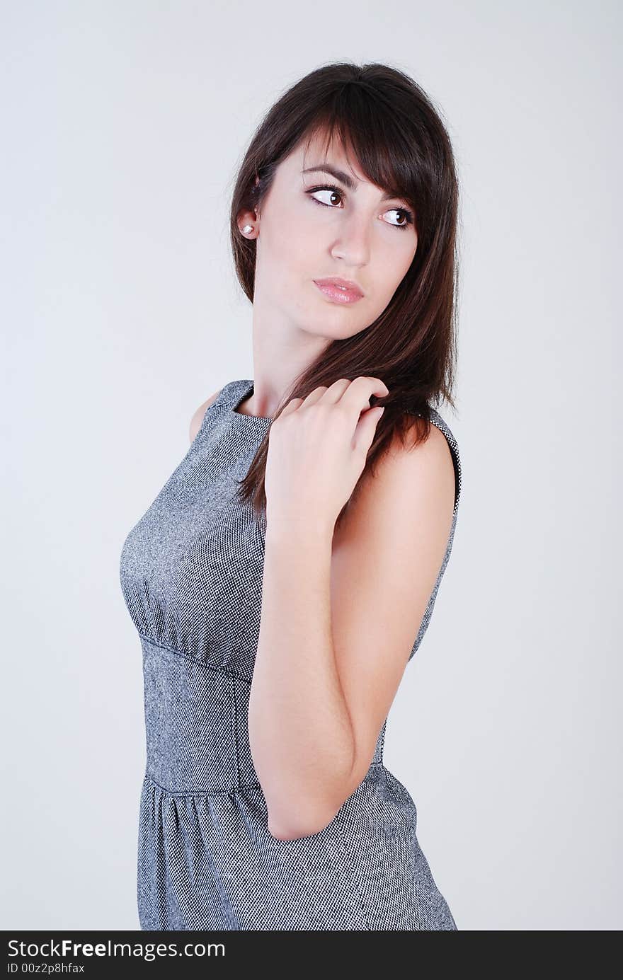 Young beautiful girl in grey clothes on a white background. Young beautiful girl in grey clothes on a white background