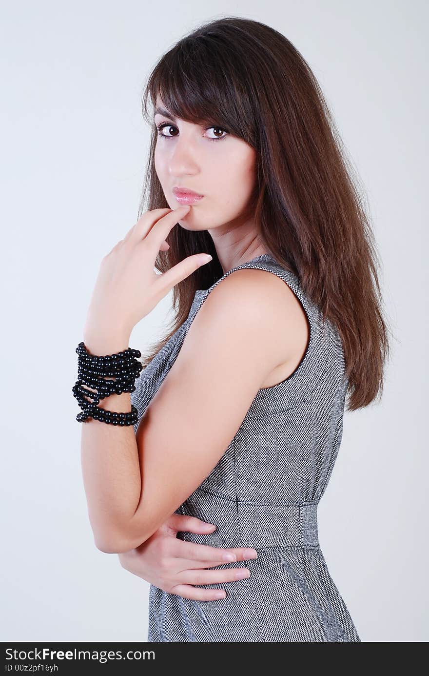 Young beautiful girl in grey clothes on a white background. Young beautiful girl in grey clothes on a white background