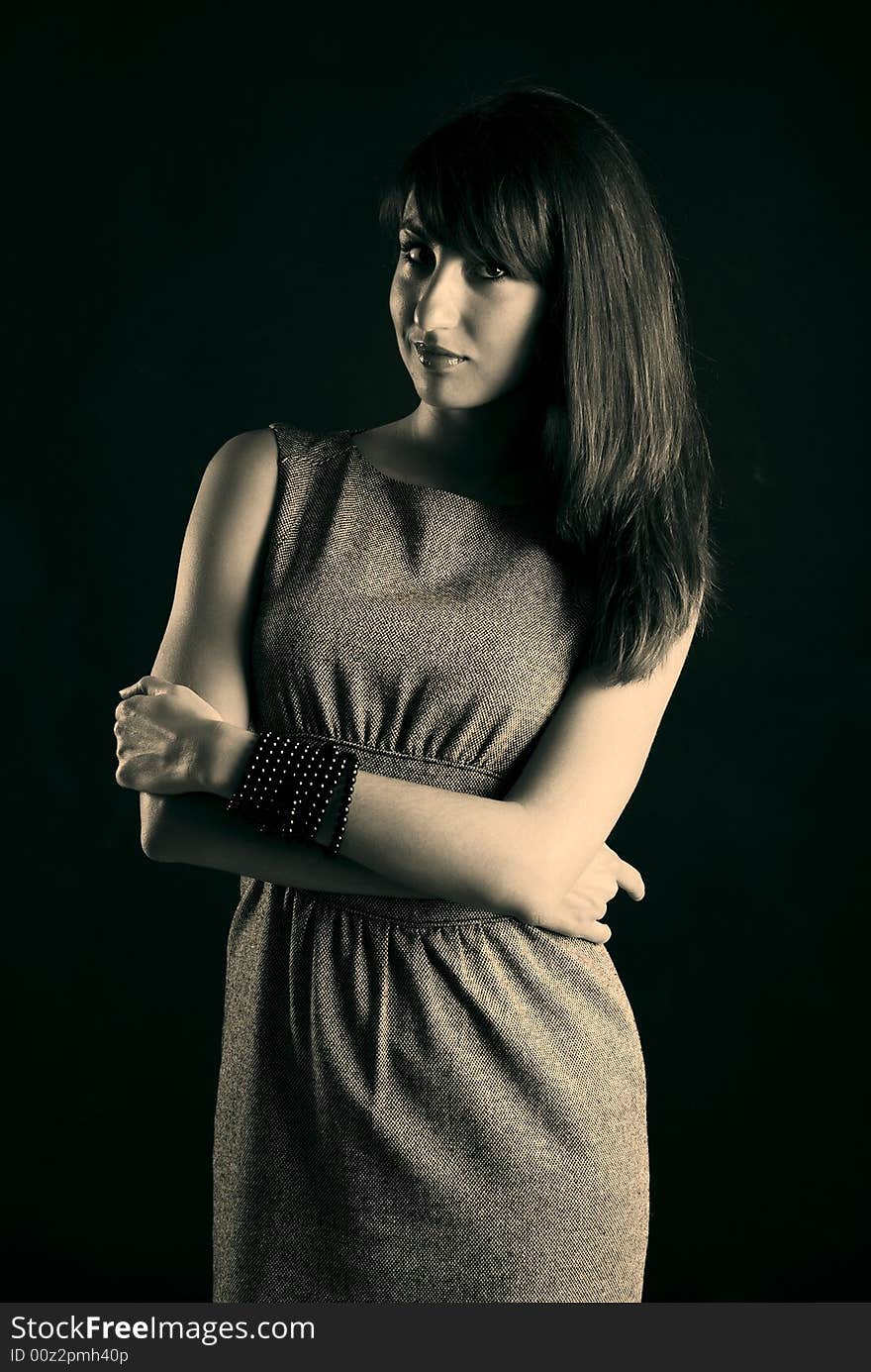 Young beautiful girl in grey clothes on a black background. Young beautiful girl in grey clothes on a black background