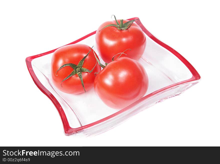 Red tomatoes on a glass plate,isolated. Red tomatoes on a glass plate,isolated.