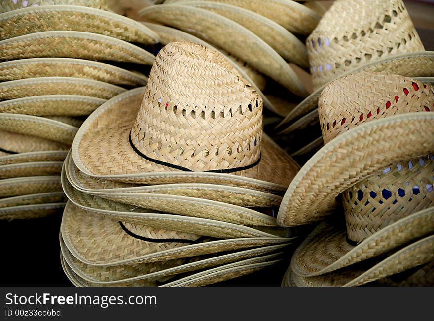 Close up image of stacked straw cowboy hats