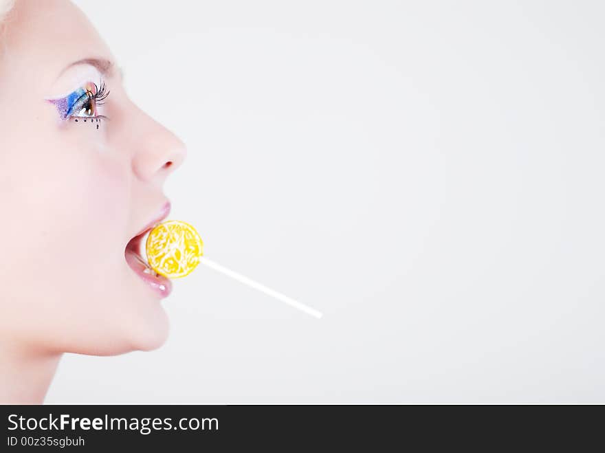 Face of beautiful girl with a lollipop in her mouth, on a white background. Face of beautiful girl with a lollipop in her mouth, on a white background