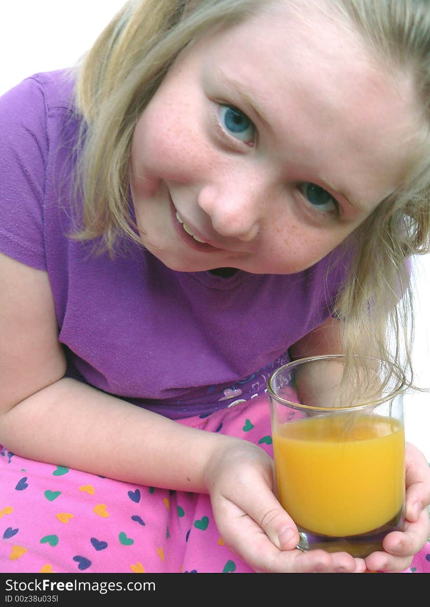 A cute little blue-eyed blond smiling and holding a glass of orange juice. A cute little blue-eyed blond smiling and holding a glass of orange juice