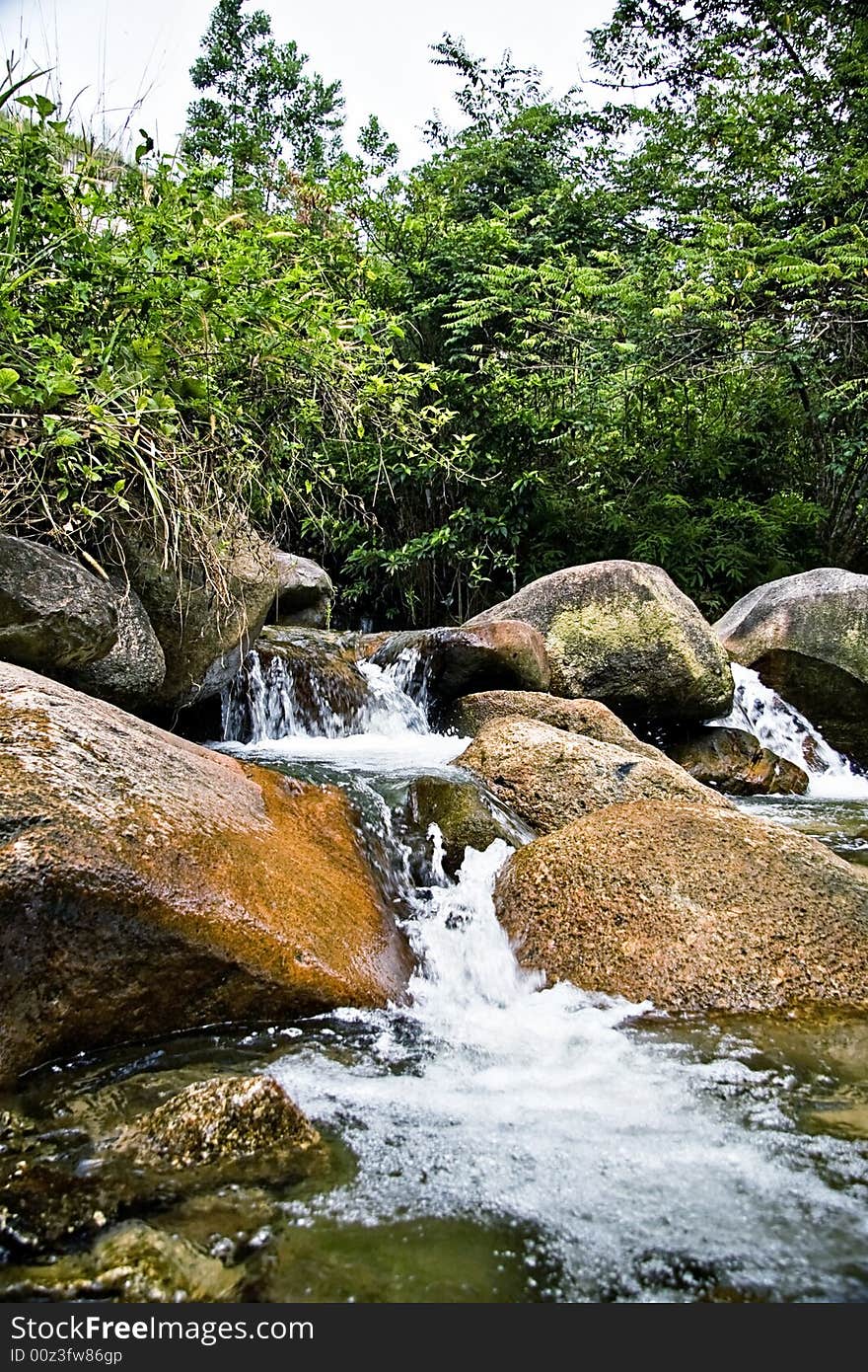 A tropical rainforest rich with fresh flowing river such as this Pisang River, making a small waterfall as it descent among the rocks on higher ground.