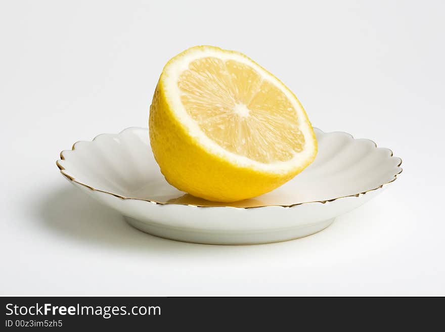 Lemon on a plate. Isolated on the white background. Clipping path included.