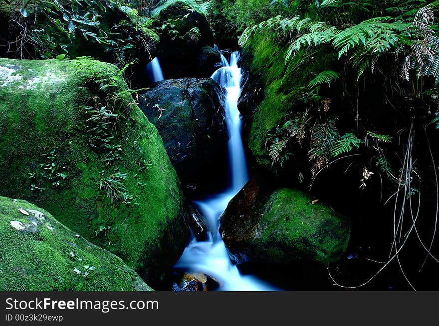 Waterfall amongst the green rocks. Waterfall amongst the green rocks