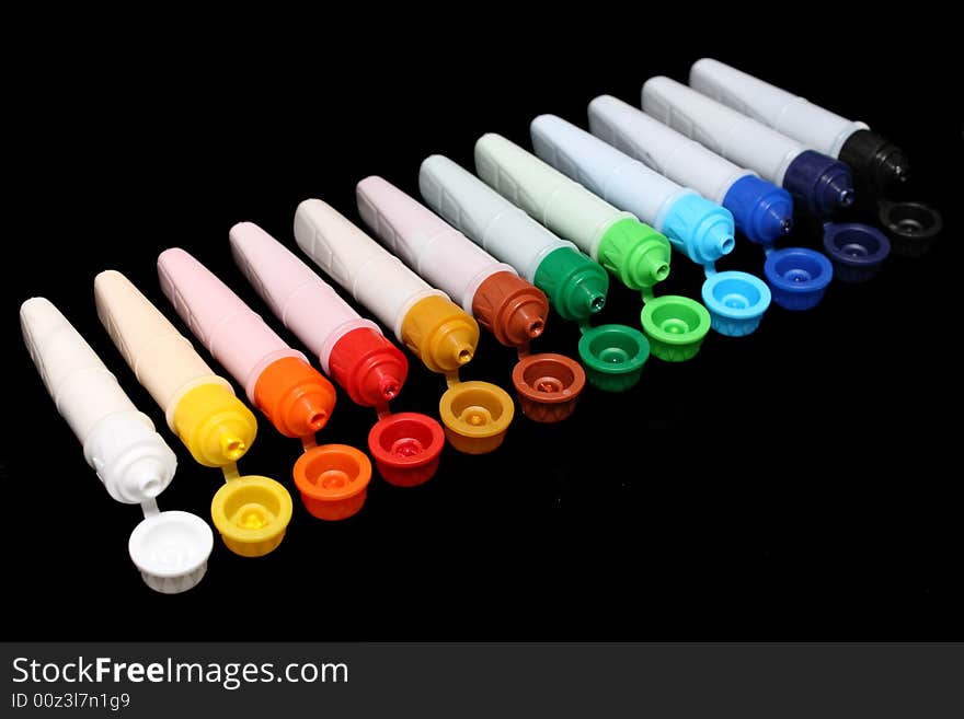 A row of colorful water colors over black background. A row of colorful water colors over black background.