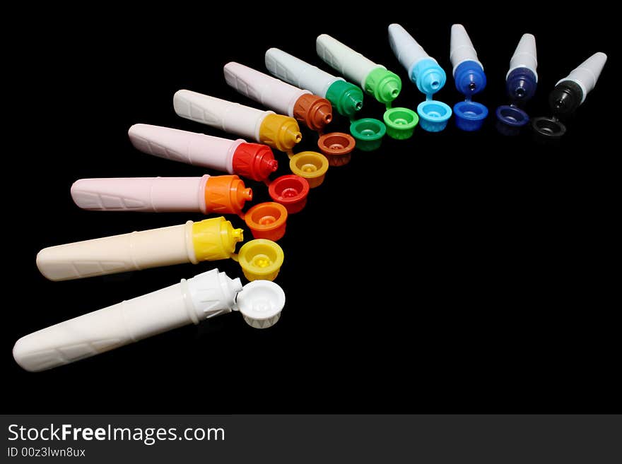 A row of colorful water colors over black background. A row of colorful water colors over black background.