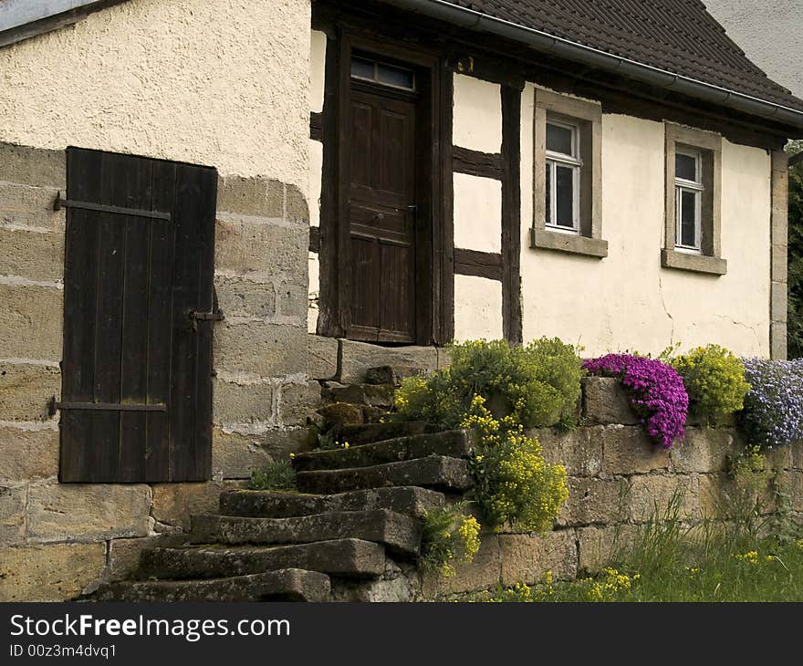 Old farmhouse with flowers in front of the door